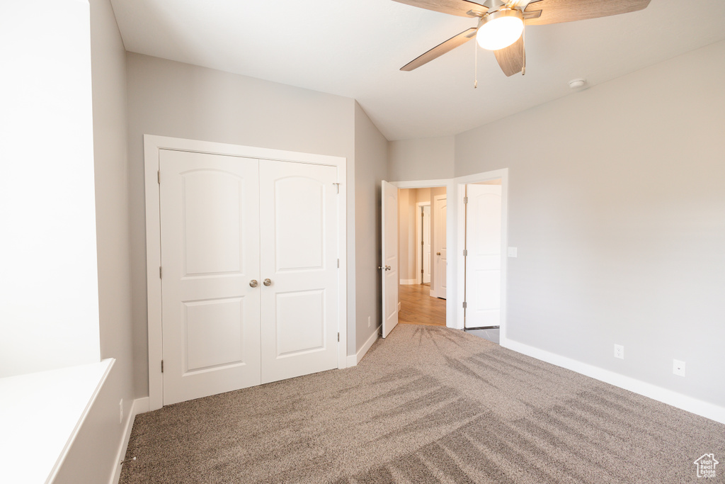 Unfurnished bedroom with carpet flooring, a closet, and ceiling fan