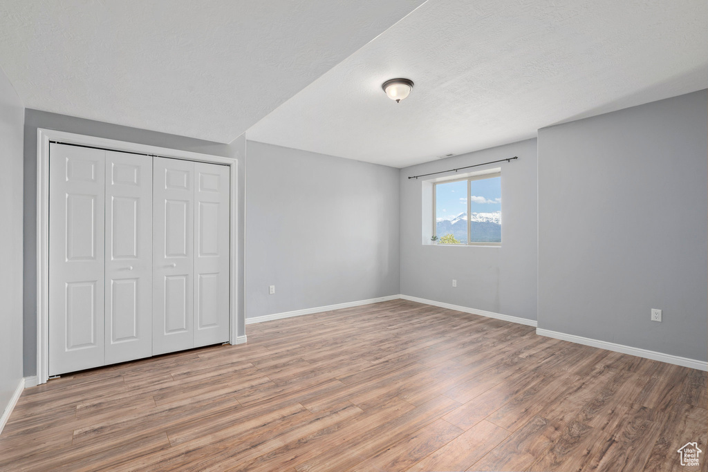 Unfurnished bedroom with a closet and hardwood / wood-style floors