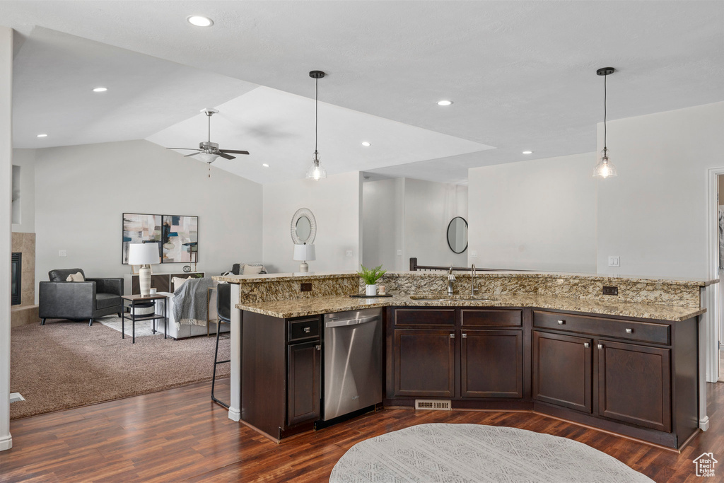 Kitchen with light stone counters, ceiling fan, stainless steel dishwasher, dark colored carpet, and pendant lighting