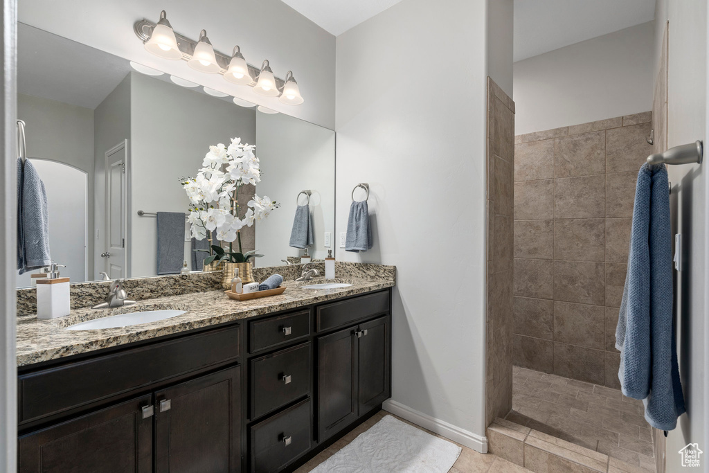 Bathroom with tile flooring, dual sinks, and vanity with extensive cabinet space