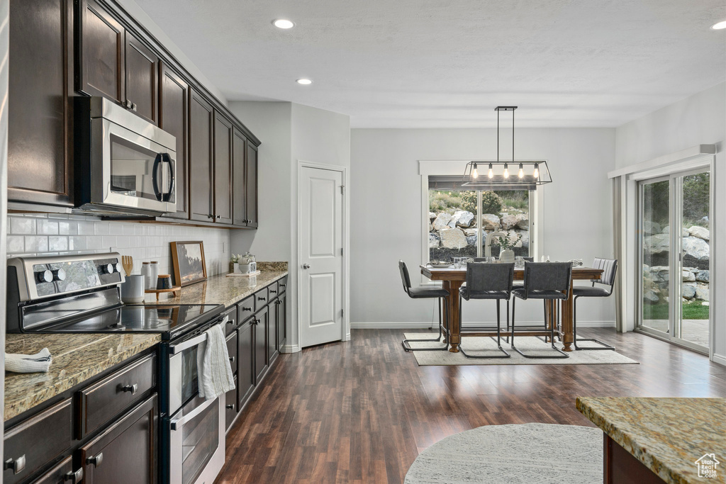 Kitchen featuring plenty of natural light, stainless steel appliances, and dark wood-type flooring