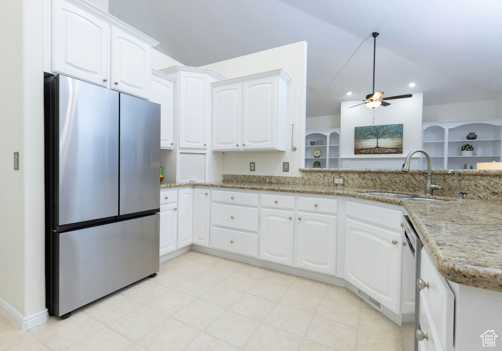 Kitchen featuring white cabinets, light tile floors, sink, stainless steel fridge, and ceiling fan