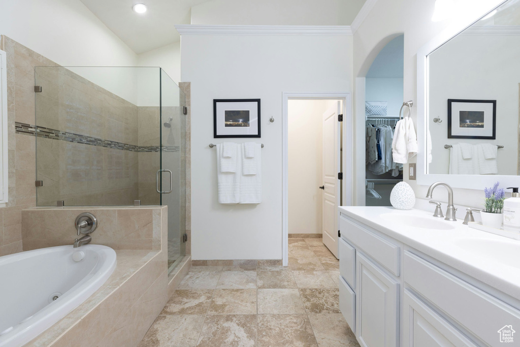 Bathroom featuring separate shower and tub, vanity with extensive cabinet space, and tile flooring