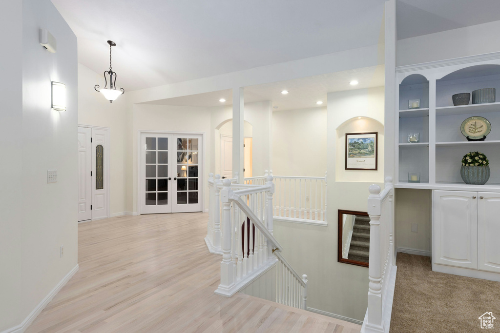 Hallway featuring french doors and light hardwood / wood-style flooring