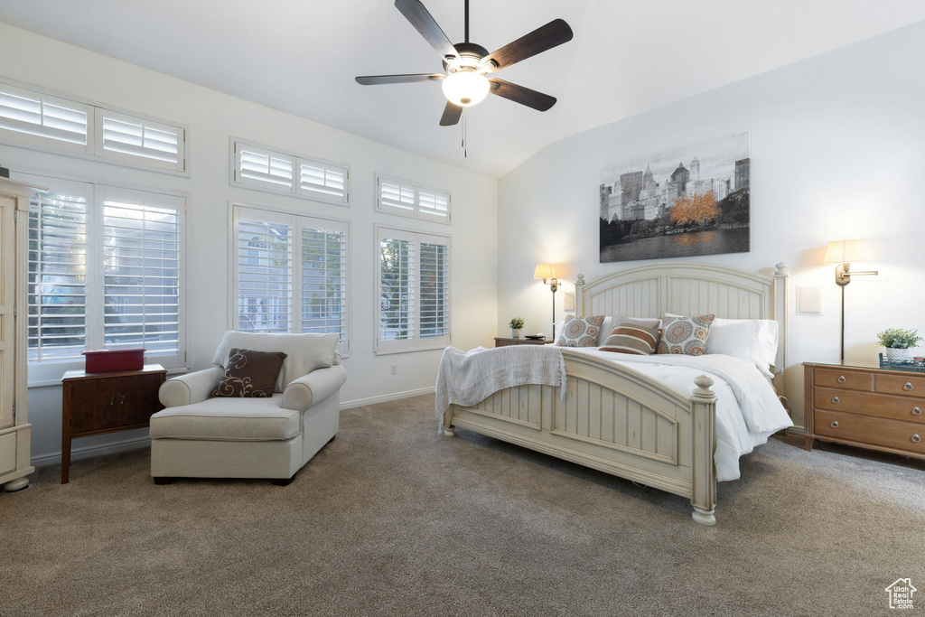 Bedroom with dark carpet, ceiling fan, and lofted ceiling
