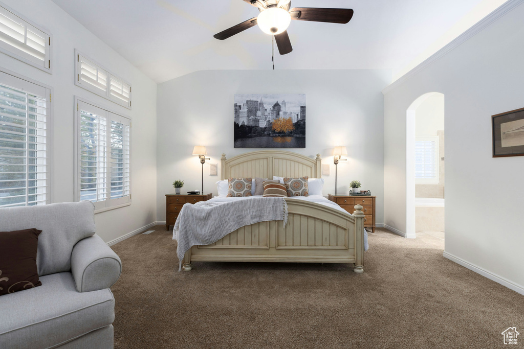 Bedroom with connected bathroom, ceiling fan, and carpet flooring