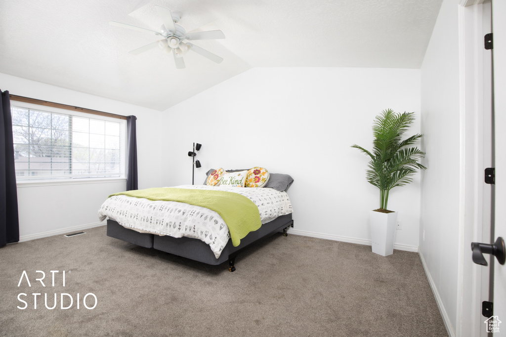Carpeted bedroom featuring lofted ceiling and ceiling fan