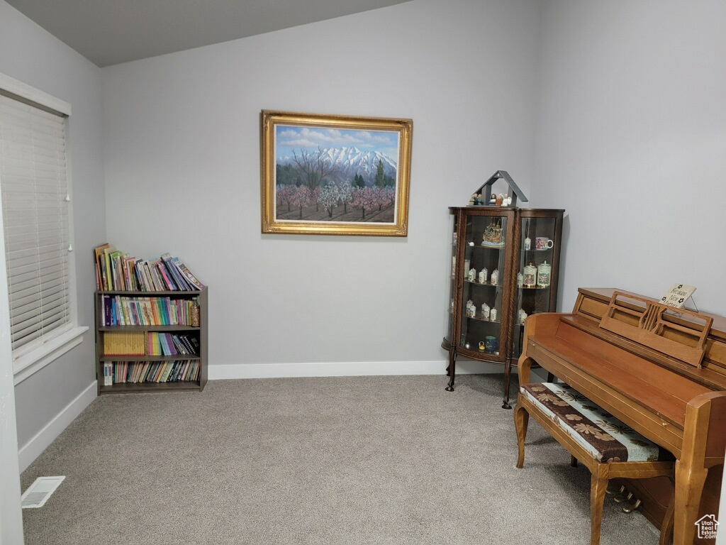 Sitting room featuring vaulted ceiling and carpet flooring