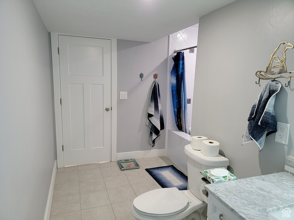 Full bathroom with tile floors, vanity, shower / bath combo, and toilet