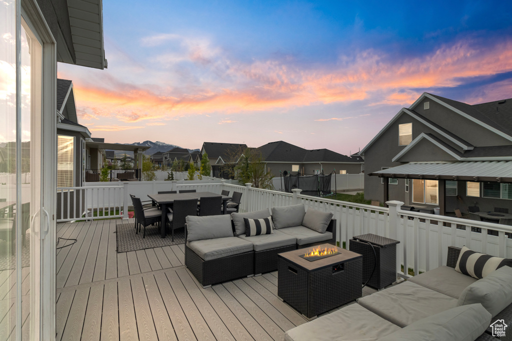 Deck at dusk with an outdoor living space with a fire pit