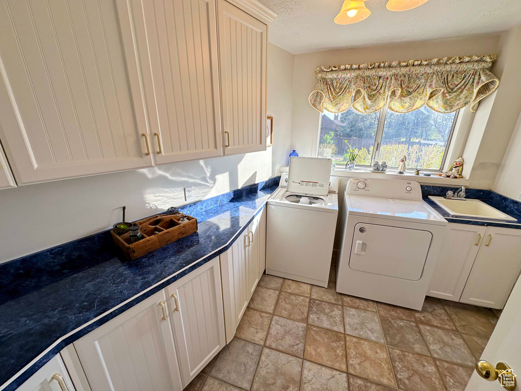 Kitchen with separate washer and dryer, light tile floors, and sink