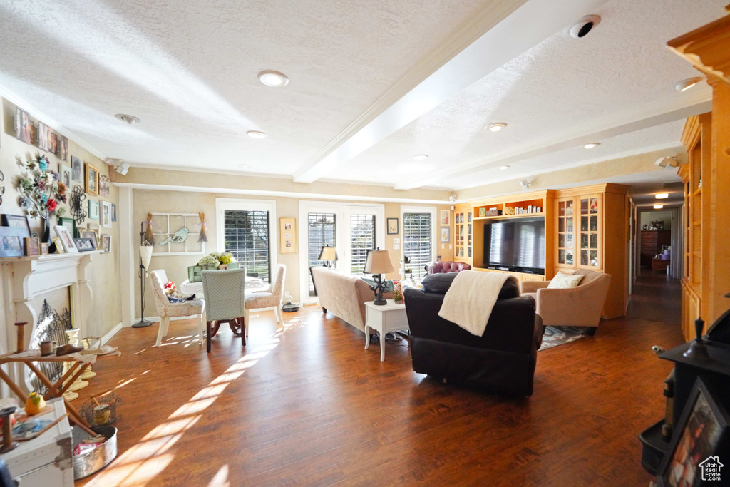 Living room with beamed ceiling, hardwood / wood-style floors, and a textured ceiling