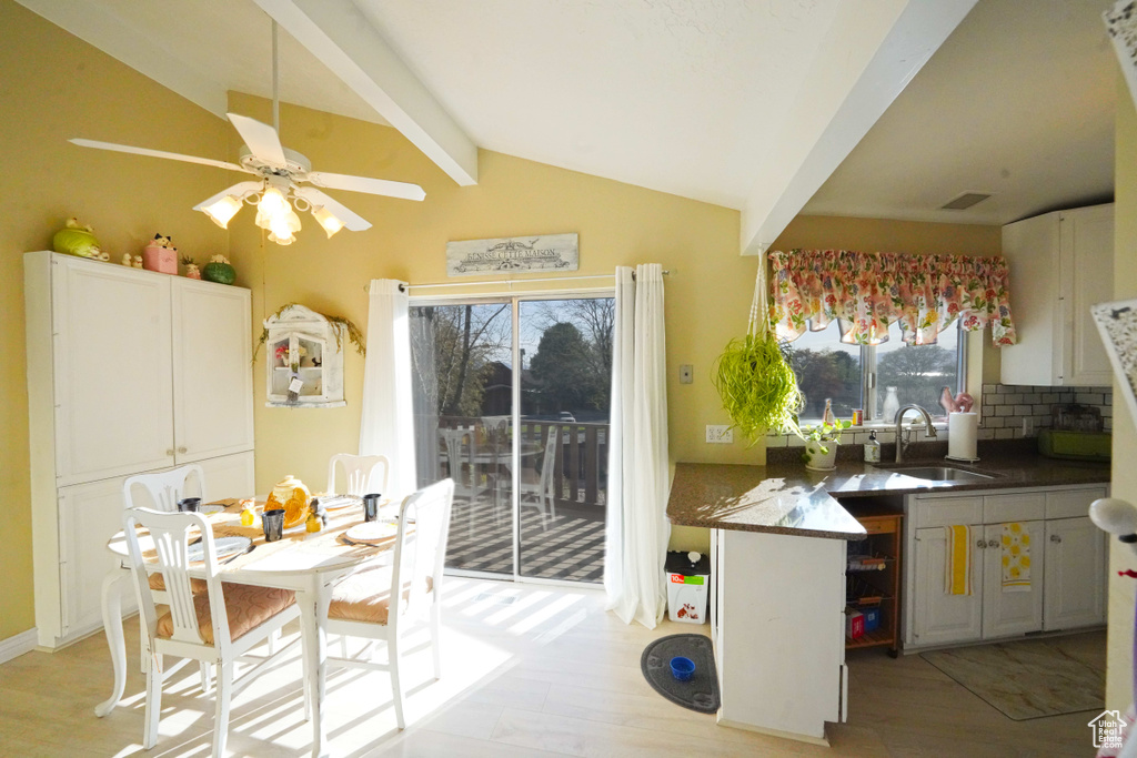 Kitchen featuring plenty of natural light, lofted ceiling with beams, ceiling fan, and sink