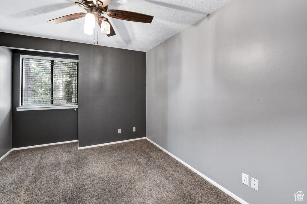 Unfurnished room featuring a textured ceiling, ceiling fan, and carpet floors