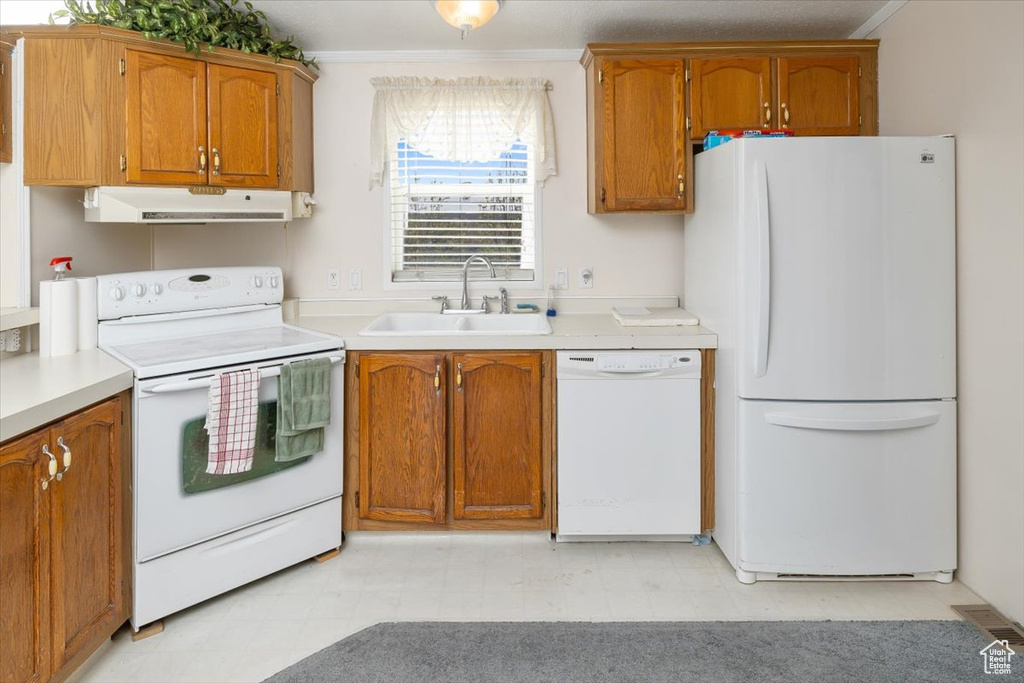 Kitchen featuring ornamental molding, sink, white appliances, and light tile floors