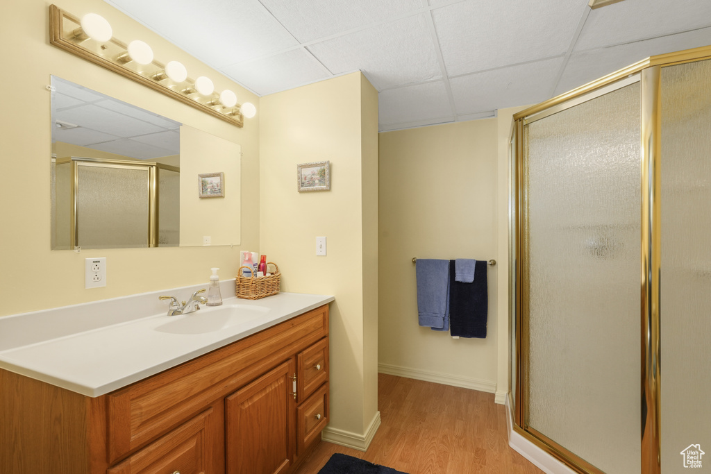 Bathroom featuring walk in shower, vanity, wood-type flooring, and a paneled ceiling