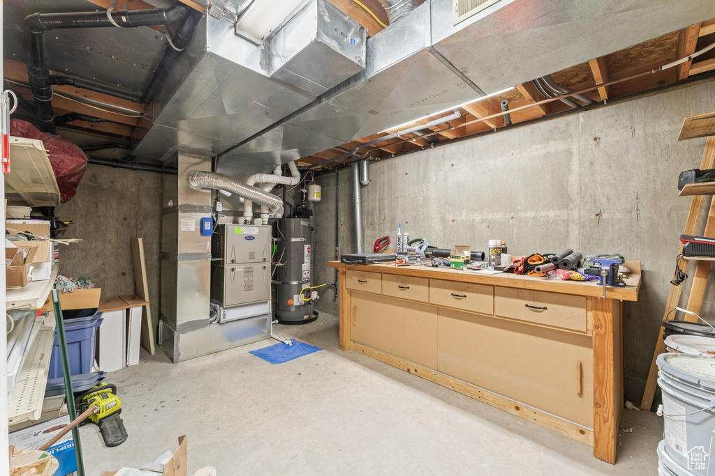 Basement featuring strapped water heater and a workshop area