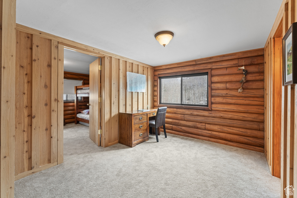 Interior space with log walls and carpet flooring