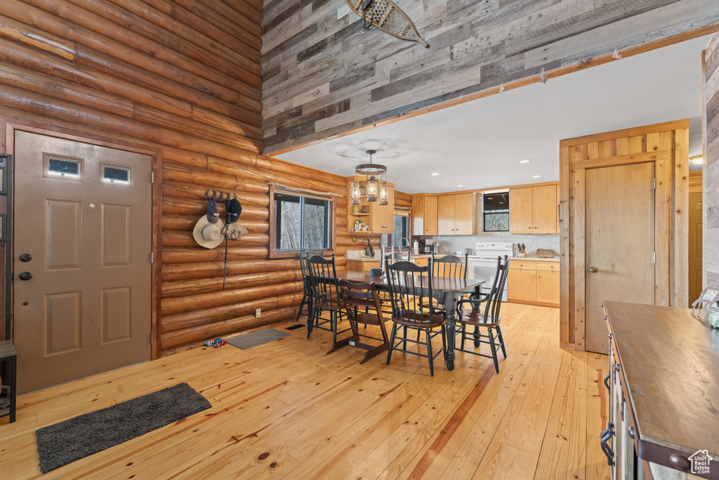 Dining area featuring light hardwood / wood-style flooring and rustic walls