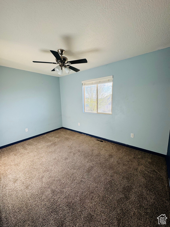 Unfurnished room with a textured ceiling, ceiling fan, and carpet