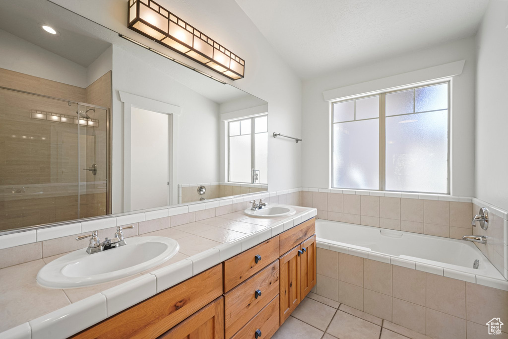 Bathroom with lofted ceiling, oversized vanity, a healthy amount of sunlight, and double sink