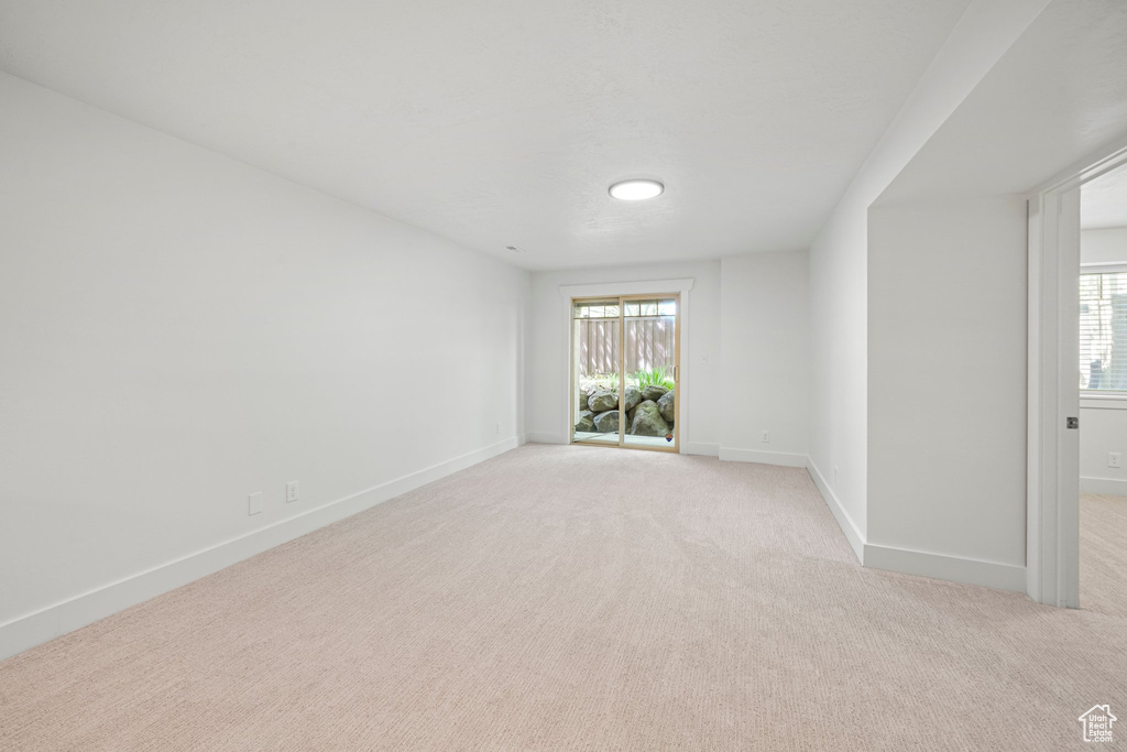 Unfurnished room with a healthy amount of sunlight and light carpet