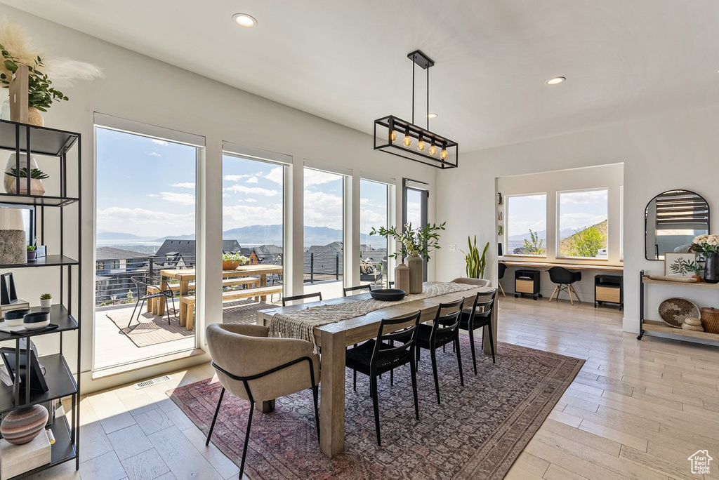Dining area with a healthy amount of sunlight, a mountain view, and light hardwood / wood-style floors