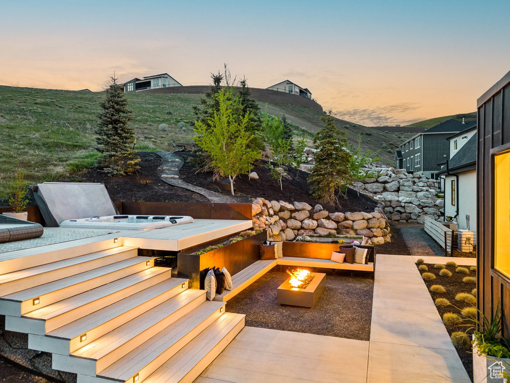 Patio terrace at dusk featuring an outdoor fire pit