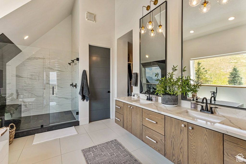 Bathroom with high vaulted ceiling, an enclosed shower, double vanity, and tile flooring