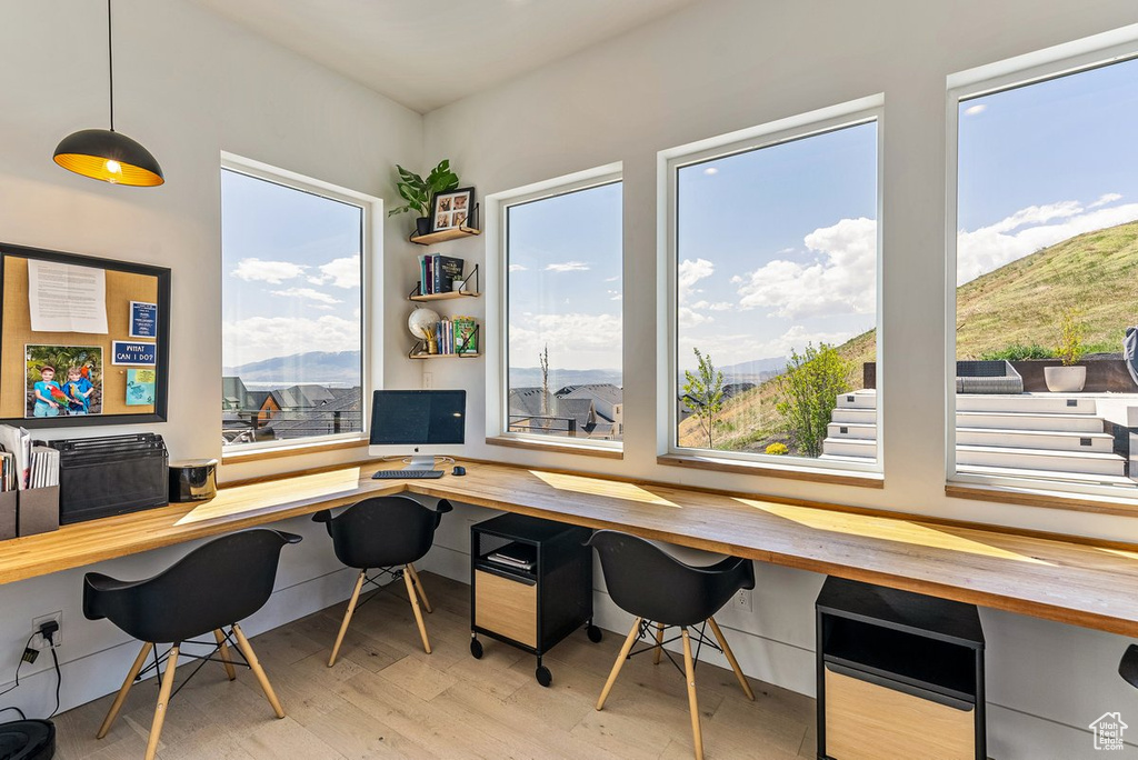 Office featuring a wealth of natural light, light hardwood / wood-style flooring, and a mountain view
