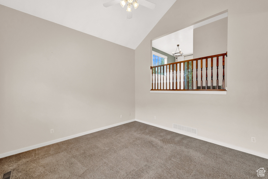 Carpeted spare room with high vaulted ceiling and ceiling fan