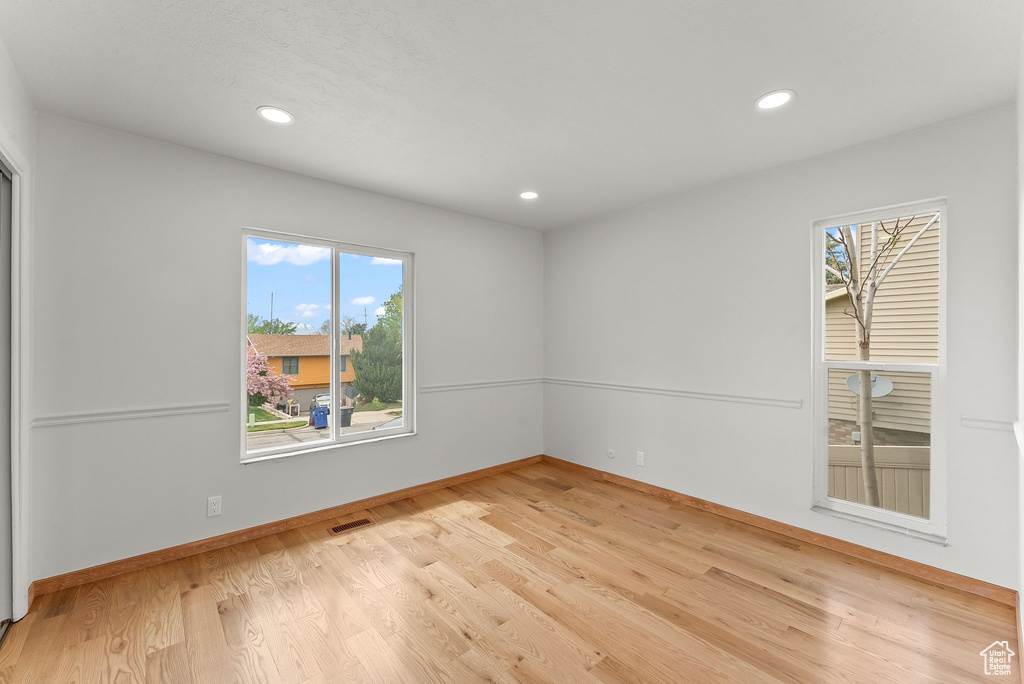 Empty room featuring light hardwood / wood-style floors and plenty of natural light
