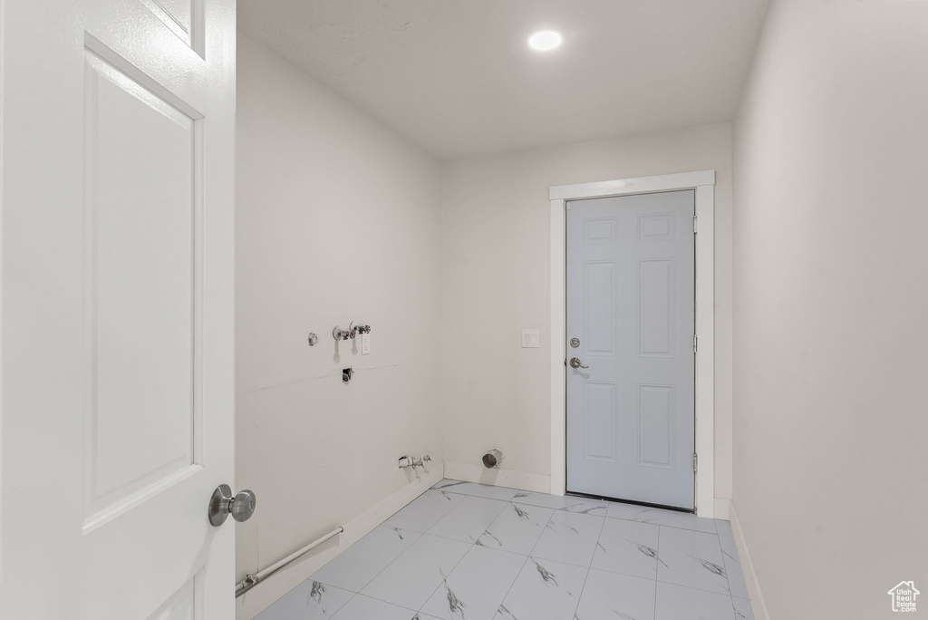 Washroom with hookup for a gas dryer and light tile floors