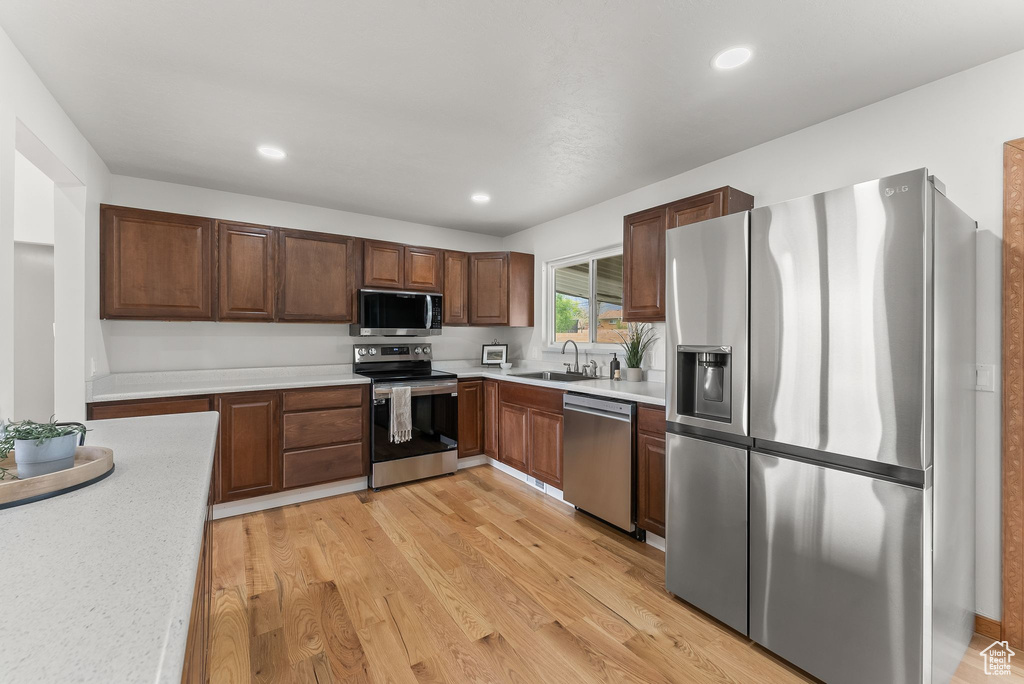Kitchen featuring sink, appliances with stainless steel finishes, and light wood-type flooring