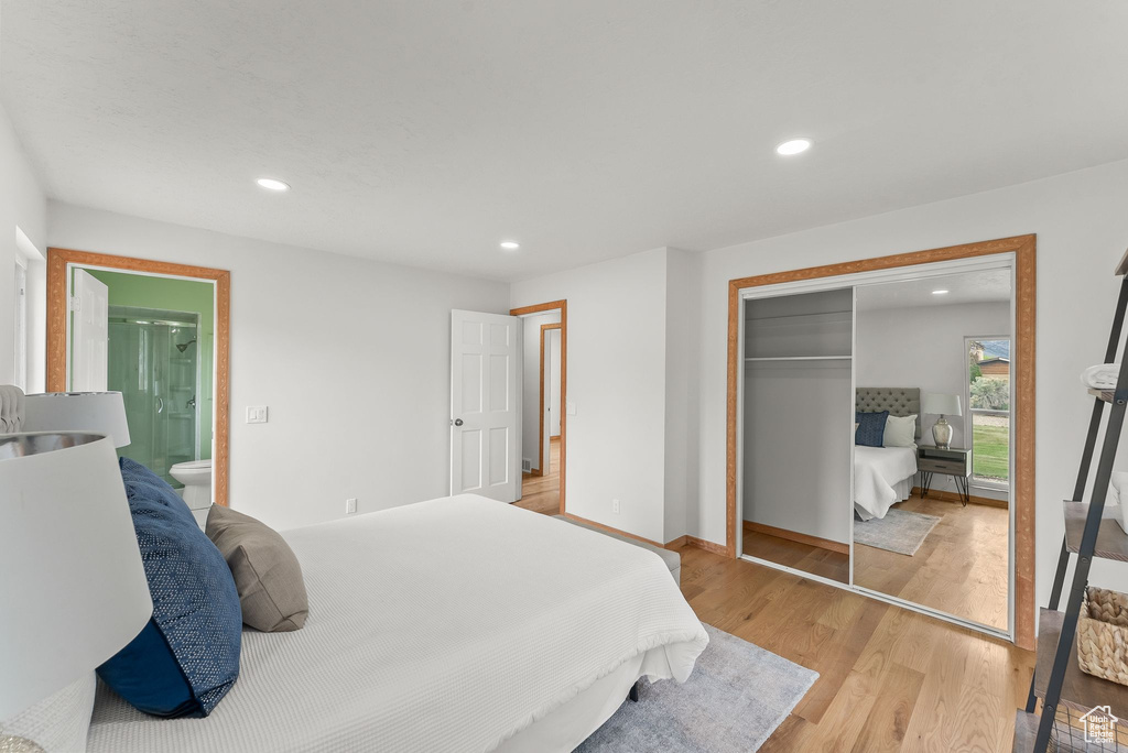 Bedroom with a closet, ensuite bath, and light hardwood / wood-style floors