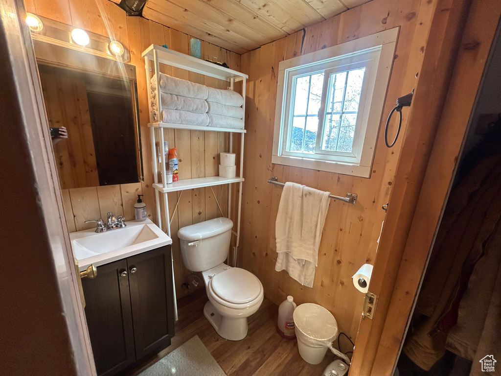 Bathroom featuring wood ceiling, toilet, wood-type flooring, wood walls, and vanity