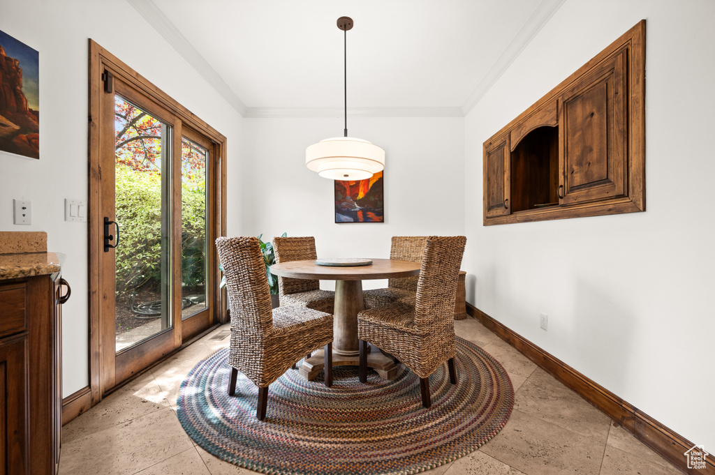 Dining space with crown molding and light tile floors
