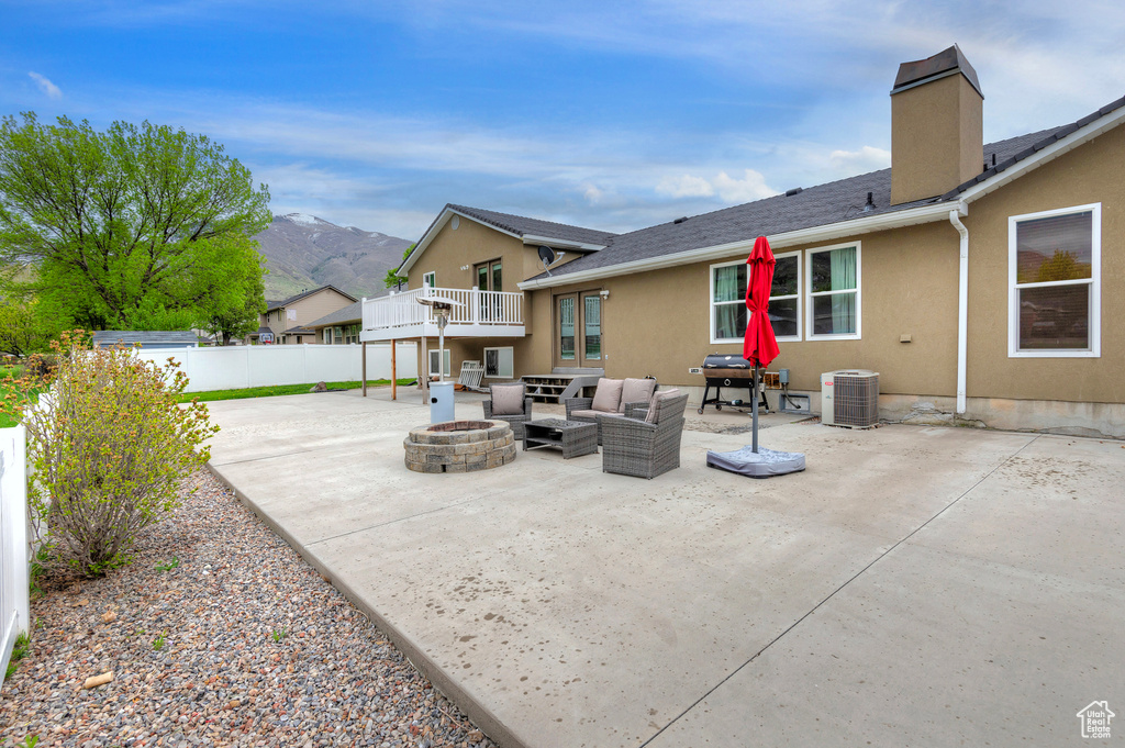 View of patio / terrace featuring a mountain view, central AC unit, and an outdoor living space with a fire pit