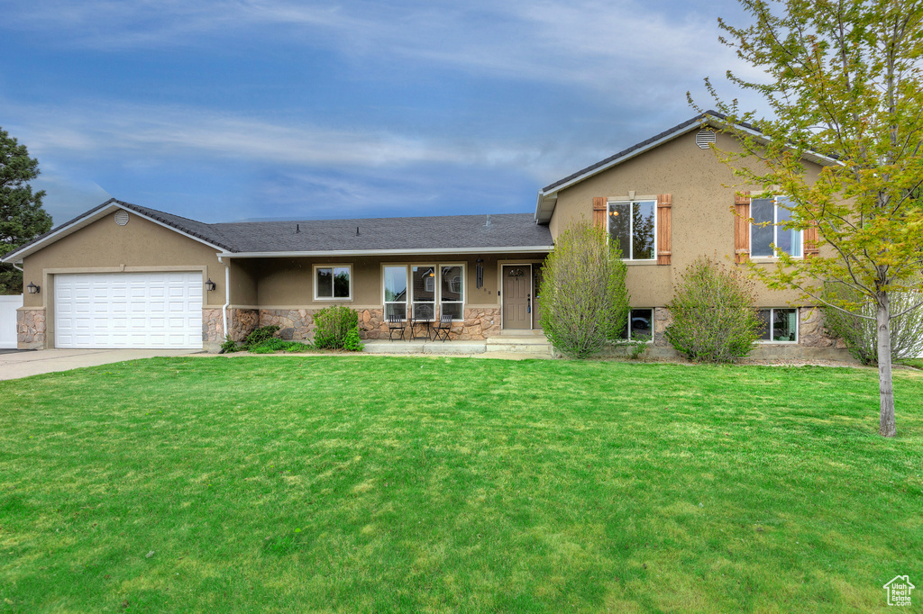 View of front of home featuring a front yard and a garage