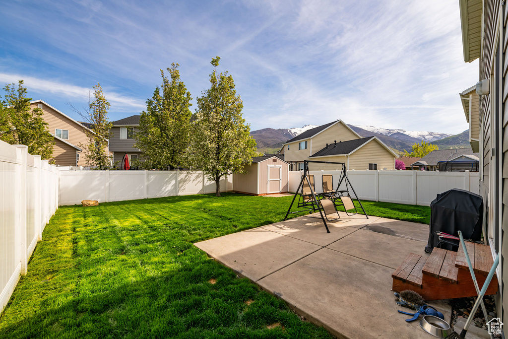 View of yard featuring a patio area, a shed, and a mountain view