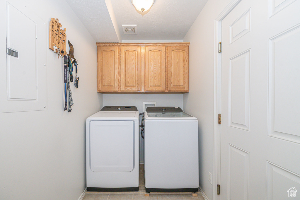 Washroom featuring independent washer and dryer, washer hookup, cabinets, and light tile flooring