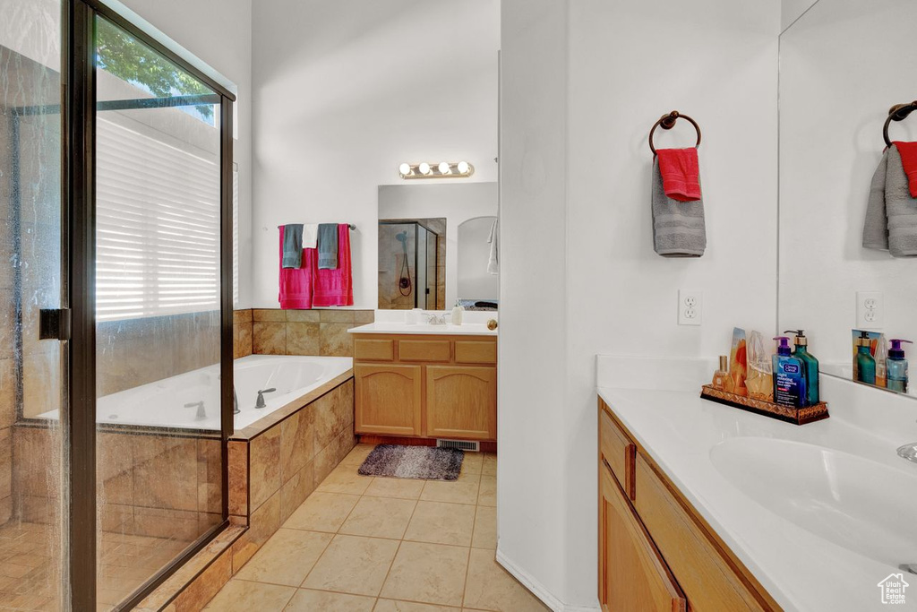 Bathroom featuring vanity, shower with separate bathtub, and tile floors