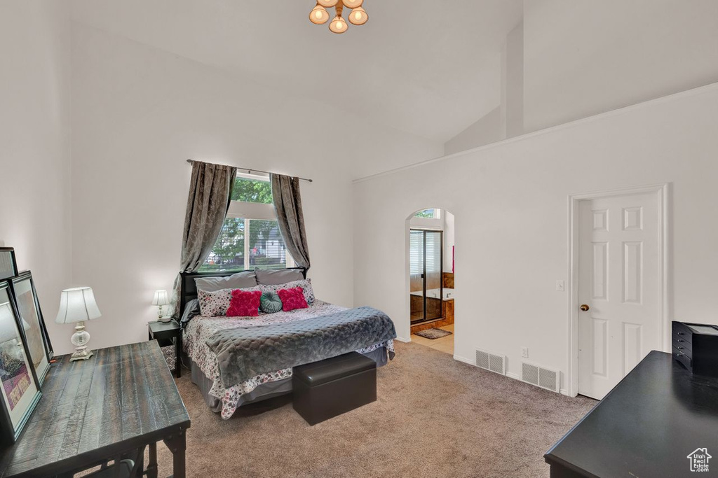 Bedroom featuring high vaulted ceiling, carpet, and ensuite bathroom