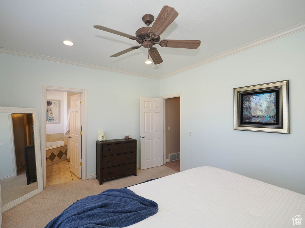 Carpeted bedroom featuring ceiling fan, crown molding, and ensuite bathroom
