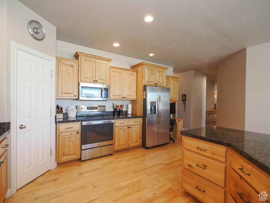 Kitchen featuring light brown cabinets, appliances with stainless steel finishes, and light hardwood / wood-style flooring