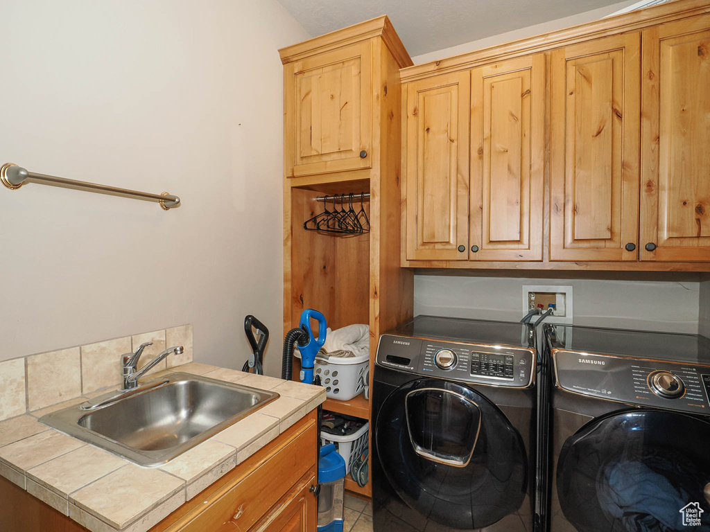 Laundry area featuring cabinets, independent washer and dryer, washer hookup, sink, and tile floors