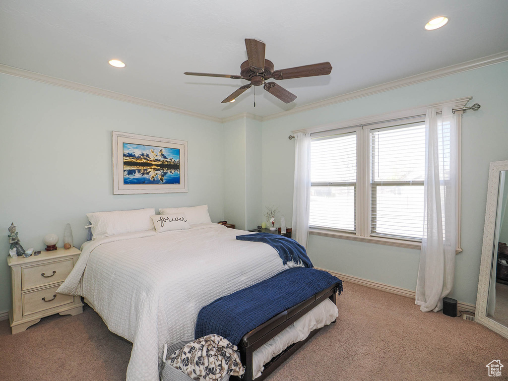 Bedroom with ornamental molding, carpet flooring, and ceiling fan