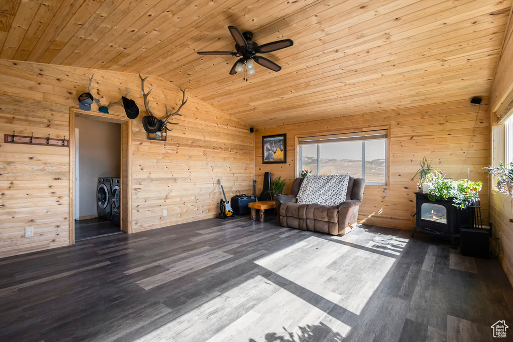 Unfurnished room with separate washer and dryer, dark wood-type flooring, and wooden walls