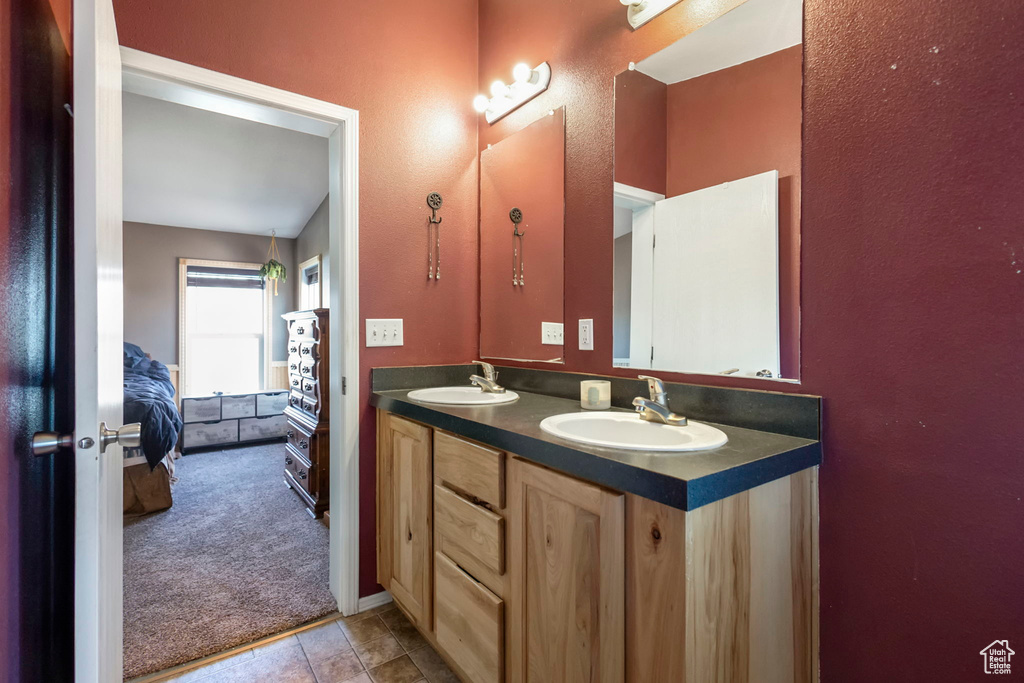 Bathroom featuring large vanity, double sink, and tile flooring