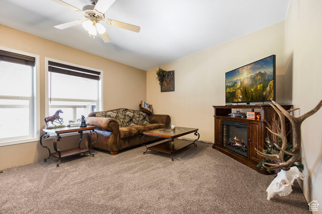 Living room featuring ceiling fan and carpet